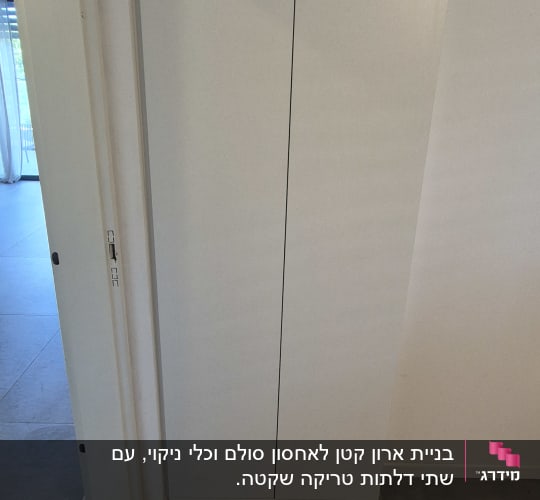 ארון לבן עם דלתות סגורות על רצפת אריחים אפורה